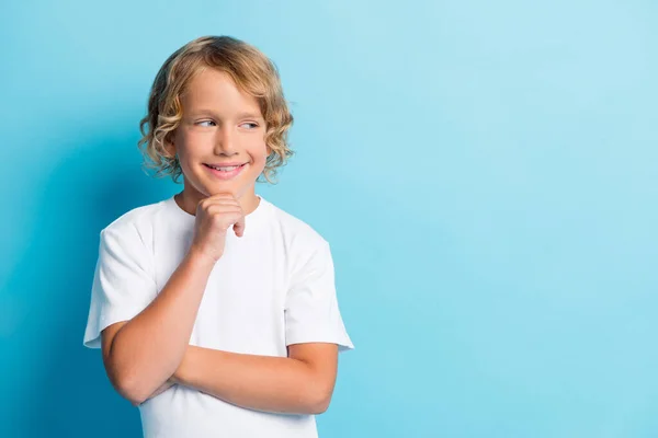 Zdjęcie małego dziecka skrzyżowane ramiona kręcone włosy błyszczący uśmiech palec podbródek wygląd puste miejsce nosić białą koszulę odizolowany niebieski kolor tło — Zdjęcie stockowe