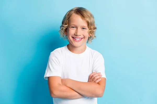 Zdjęcie małego dziecka skrzyżowane ręce faliste fryzura śmieszne zęby uśmiech nosić białą koszulę odizolowany niebieski kolor tła — Zdjęcie stockowe
