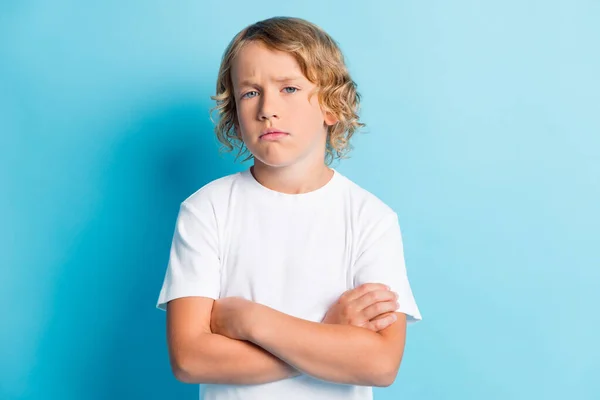 Foto de un niño joven cruzó los brazos peinado ondulado desconfianza cara desgaste camisa blanca aislado color azul fondo — Foto de Stock