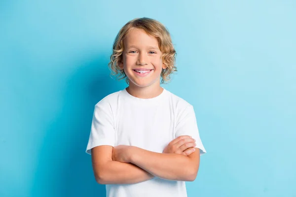 Zdjęcie młodego dziecka złożone ręce kręcone włosy zęby uśmiech nosić białą koszulę odizolowany niebieski kolor tła — Zdjęcie stockowe