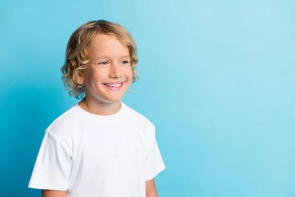 Photo positive petit garçon regarder espace vide dents souriant porter t-shirt blanc isolé sur fond de couleur bleue — Photo