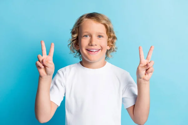 Foto do menino positivo fazer v-sinal de dente sorrindo desgaste casual estilo roupas isoladas sobre fundo de cor azul — Fotografia de Stock