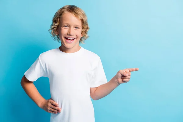 Photo positive petit garçon index de point espace vide porter t-shirt blanc isolé sur fond de couleur bleue — Photo