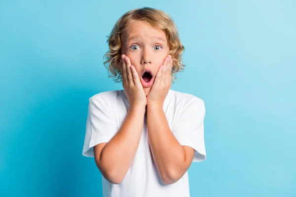 Foto de niño pequeño se siente impresionado toque manos cara desgaste traje de estilo casual aislado sobre fondo de color azul — Foto de Stock