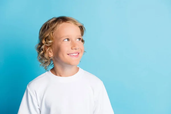 Foto do menino sorridente olhar espaço vazio desgaste t-shirt branca isolada sobre fundo de cor azul — Fotografia de Stock