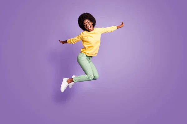 Full body foto van gek Afrikaans meisje springen hold handen vliegtuig vliegen spel concept geïsoleerd op violette kleur achtergrond — Stockfoto