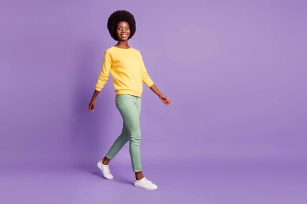 Full length profile side photo of positive afro ameriacn girl go empty space isolated over purple color background — Stock Photo, Image