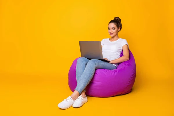 Full size photo of focused smart girl sit purple bag bean work computer read colleagues report document wear style stylish trendy sneakers isolated over bright shine color background — Zdjęcie stockowe