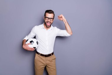 Photo of handsome excited guy with beard bristle watching football holding sport ball in hands supporting team isolated over grey collor background clipart
