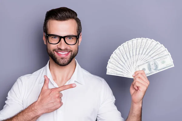 Portrait of positive man manager ceo investor hold money fan point index finger recommend bank income cashback service wear white shirt isolated over gray color background — ストック写真