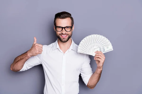 Portrait of positive manager economist promoter hold money fan show thumb-up sign approve income profit cashback wear white shirt isolated over gray color background — Stock Photo, Image