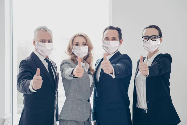 Portret van bekwame slimme zakenmensen die duimspuiten in werkplek met veiligheidsmaskers stoppen pandemie — Stockfoto