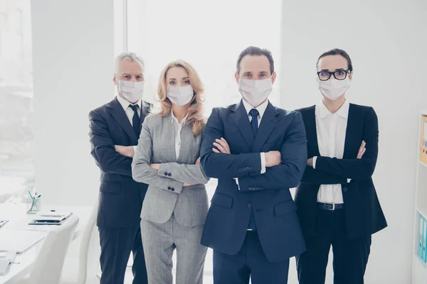 Portret van aantrekkelijke stijlvolle zakenmensen in pakken gevouwen armen staande op werkplek met veiligheidsmaskers — Stockfoto