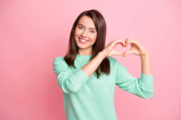 Retrato de menina alegre atraente mostrando conceito de amor auto forma do coração isolado sobre fundo de cor pastel rosa — Fotografia de Stock