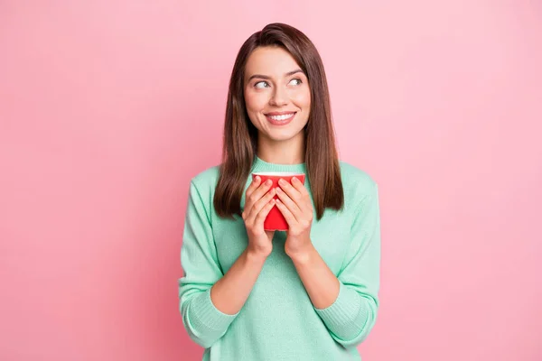 Foto de descanso bonito morena cabelo liso jovem mulher segurar café olhar espaço vazio desgaste suéter isolado no fundo cor-de-rosa — Fotografia de Stock