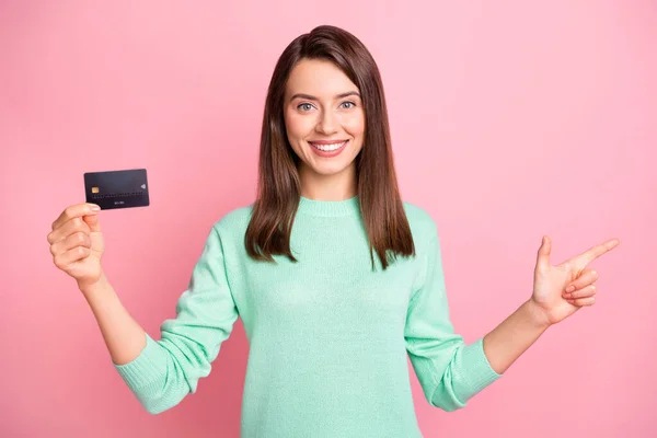 Retrato de positivo agradável morena jovem ponto espaço vazio promover cartão de crédito isolado no fundo cor-de-rosa — Fotografia de Stock