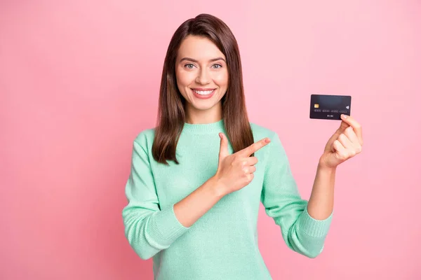 Фото леди держать кредитную карту прямой палец сияющий улыбка носить бирюзовый свитер изолированный розовый цвет фона — стоковое фото
