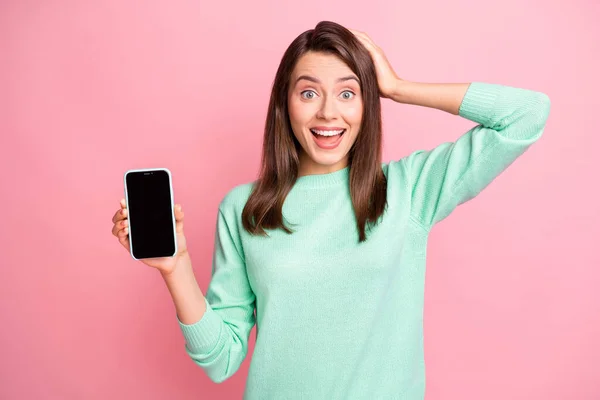 Foto de menina segurar smartphone touchscreen vazio espaço braço cabeça desgaste turquesa suéter isolado cor-de-rosa fundo — Fotografia de Stock
