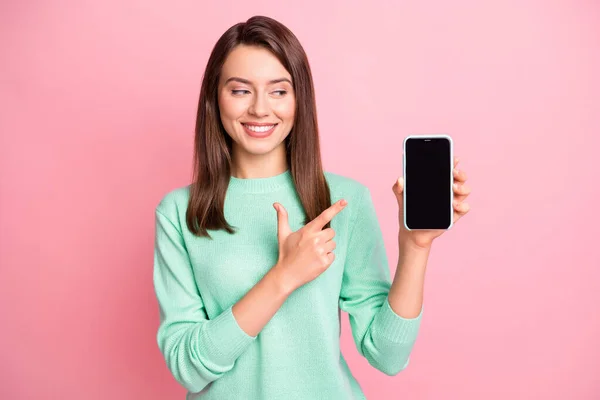 Foto de senhora segurar telefone direto dedo olhar tela vazio espaço desgaste teal suéter isolado cor-de-rosa fundo — Fotografia de Stock