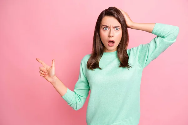 Photo of mad puzzled girl hand head direct finger empty space wear turquoise pullover isolated pink color background — Stock Photo, Image