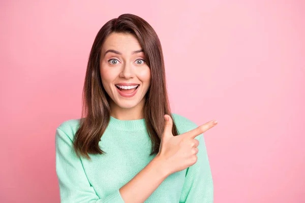 Foto van grappig vrolijk meisje directe vinger lege ruimte dragen turquoise trui geïsoleerde roze kleur achtergrond — Stockfoto