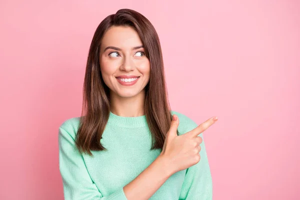 Photo of lovely girl direct forefinger look empty space toothy smile wear teal pullover odizolowany różowy kolor tła — Zdjęcie stockowe