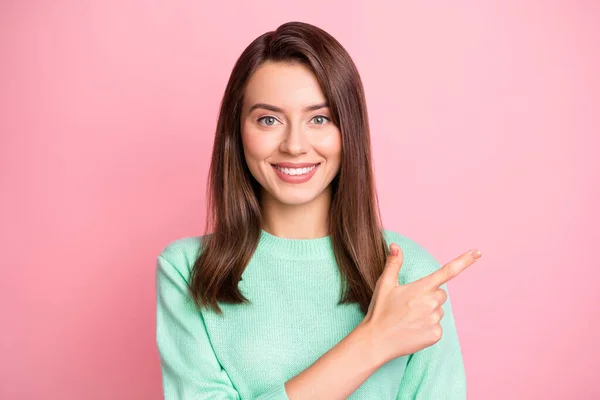 Foto de chica joven encantadora indican dedo índice vacío espacio desgaste jersey turquesa aislado color rosa fondo — Foto de Stock