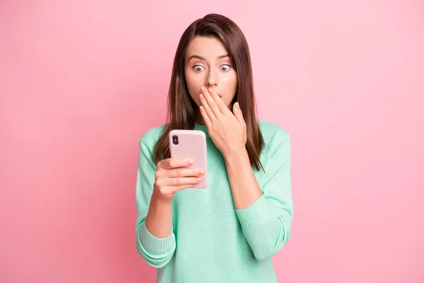 Foto de menina sem palavras segurar smartphone mão fechar boca olhar tela desgaste teal pulôver isolado cor-de-rosa fundo — Fotografia de Stock