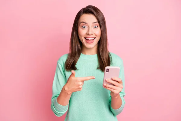 Foto de atraente estudante braço ponto dedos telefone positivo emoção estilo suéter isolado no fundo cor-de-rosa — Fotografia de Stock