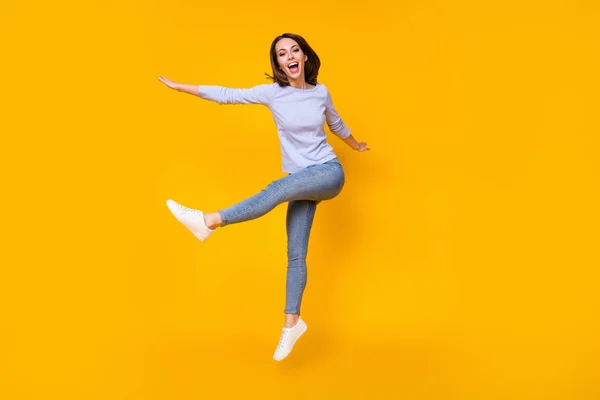 Comprimento total do corpo tamanho vista dela, ela atraente muito bonito funky alegre alegre menina saltando se divertindo brincando dançando isolado brilhante vívido brilho vibrante cor amarela fundo — Fotografia de Stock