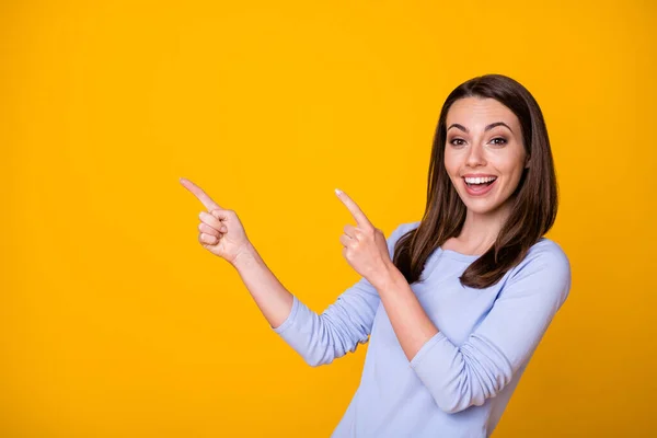 Foto av attraktiva glada glada dam direkt fingrar sida tomt utrymme gott humör visar nyhet banner shopping säsong öppning slitage casual shirt isolerad gul färg bakgrund — Stockfoto