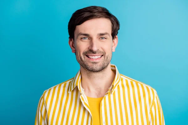 Portret van tevreden aantrekkelijke man kijken goed humeur in camera tand glimlachen slijtage gestreept geel shirt geïsoleerd over blauwe kleur achtergrond — Stockfoto