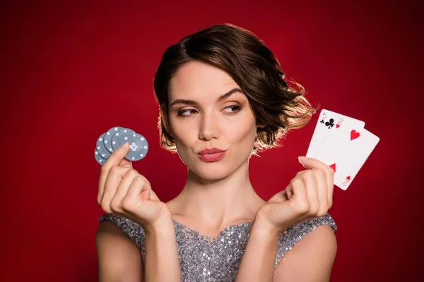 Nahaufnahme Foto der attraktiven Dame professionelle Casino-Spieler halten Chips zwei Kartenspiele Wette riskant denken über nächsten cleveren Zug tragen Glanzkleid isoliert dunkelroten Farbverlauf Hintergrund — Stockfoto