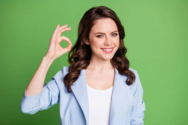 Photo of charming lady curly hairdo hand demonstrate okey wear blue jacket isolated green color background