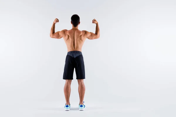 Full length rear behind photo of handsome muscular sportsman dark skin guy showing arms biceps ideal body constitution naked chest wear only shorts sneakers isolated white color background — Stock Photo, Image