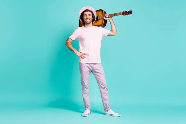 Full size photo of nice stylish guy stand with guitar wear cap trousers sneakers isolated on teal color background — Stock Photo, Image