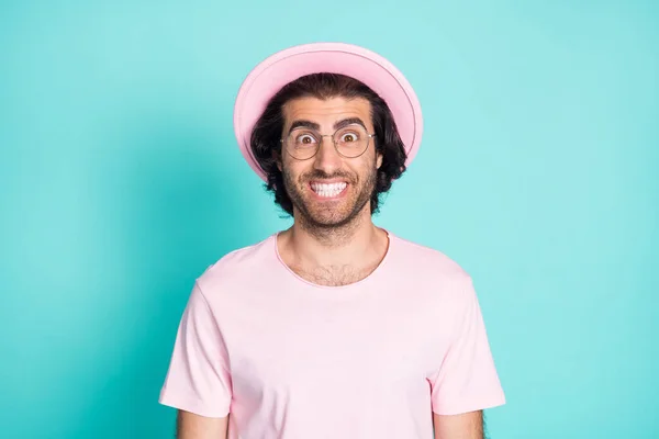 Φωτογραφία πορτρέτο του τρελού άνδρα χαμογελώντας με λευκά δόντια φορώντας ροζ t-shirt γυαλιά καπέλο απομονώνονται σε ζωντανό φόντο teal χρώμα — Φωτογραφία Αρχείου