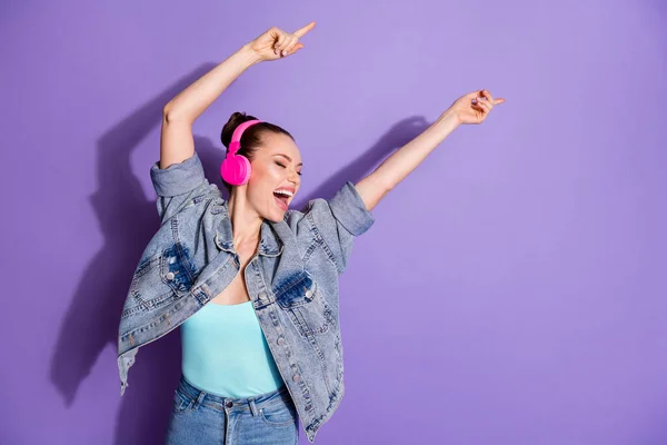 Retrato de chica joven divertida cool disfrutar de pausa de descanso escuchar radio melodía auriculares danza levantar las manos usar ropa de buen aspecto aislado sobre fondo de color violeta — Foto de Stock