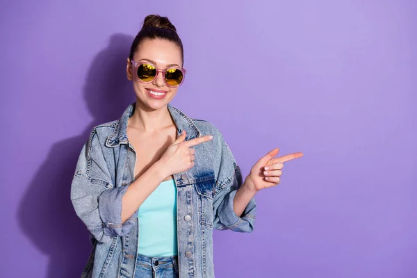 Retrato de positivo alegre menina promotor ponto indicador dedo presente anúncios promo forma direta vendas desgaste singlet isolado sobre cor violeta fundo — Fotografia de Stock