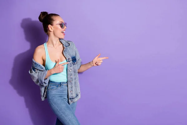 Profile side photo of positive cheerful girl promoter point index finger copyspace demonstrate incredible ads promotion wear tank-top isolated over violet color background — Stock Photo, Image