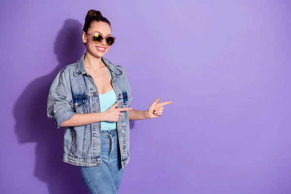 Portrait of positive cheerful girl point index finger copyspace present adverts promo recommend suggest select wear good look streetstyle clothes isolated over purple color background — Stock Photo, Image