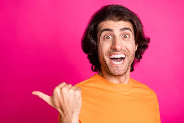 Фото молодої людини прямий палець порожній простір відкритий рот одягнений помаранчевою футболкою ізольований рожевий кольоровий фон — стокове фото