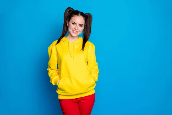 Photo of attractive amazing lady funny two tails hairdo toothy beaming smiling good mood wear casual yellow sweatshirt pullover red pants isolated bright blue color background — Zdjęcie stockowe