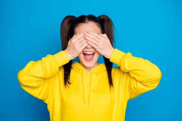 Foto von ziemlich lustigen Dame zwei Schwänze Frisur Arme auf Augen Suchenden spielen Versteckspiel tragen lässig gelben Sweatshirt Pullover isoliert helle blaue Farbe Hintergrund — Stockfoto