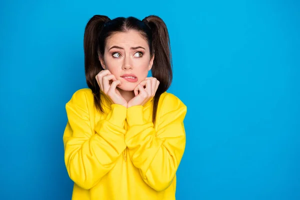 Foto de senhora bonita duas caudas penteado braços em maçãs do rosto olhar medo lado vazio espaço feito erro situação desconfortável desgaste amarelo camisola pulôver isolado brilhante azul cor fundo — Fotografia de Stock