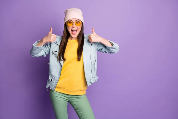 Retrato de la joven enérgica loca disfrutar de anuncios de promoción opción mostrar pulgar hacia arriba recomendar decisiones de elección usar pantalones verdes amarillos aislados sobre fondo de color violeta — Foto de Stock