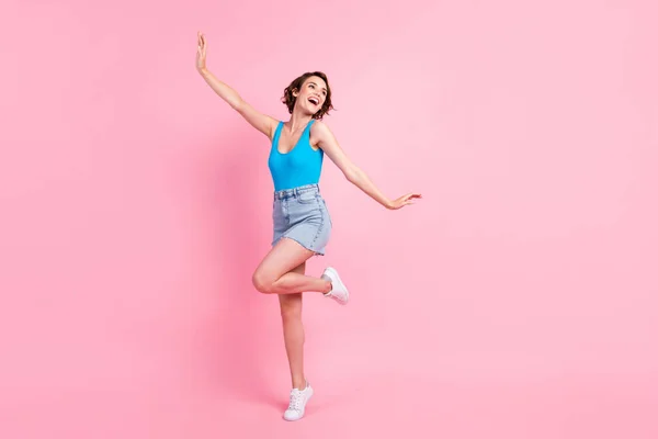 Full body size photo of cute charming student girl stay tip chilling sorrindo dreamy look open mouth weekend wear denim mini skirt blue singlet white sneakers isolated pink color background — Fotografia de Stock