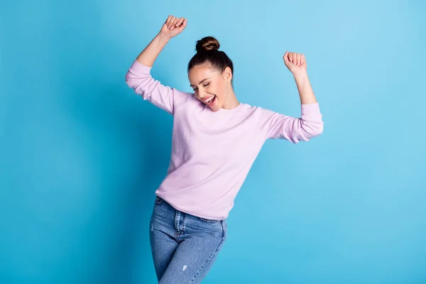 Foto van positieve vrolijke meisje genieten vreugde dans nacht club verhogen vuisten dragen goed look stemming trui geïsoleerd over blauwe kleur achtergrond — Stockfoto