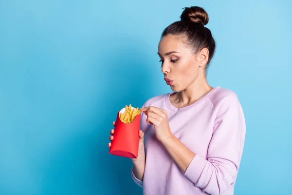 Foto av förvånad flicka imponerad välsmakande hämtmat pommes frites ser slitage violett jumper isolerad över blå färg bakgrund — Stockfoto