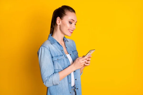 Profile side photo of positive cheerful girl use smartphone share repost subscribe social network news wear casual style outfit isolated over bright shine color background — Zdjęcie stockowe